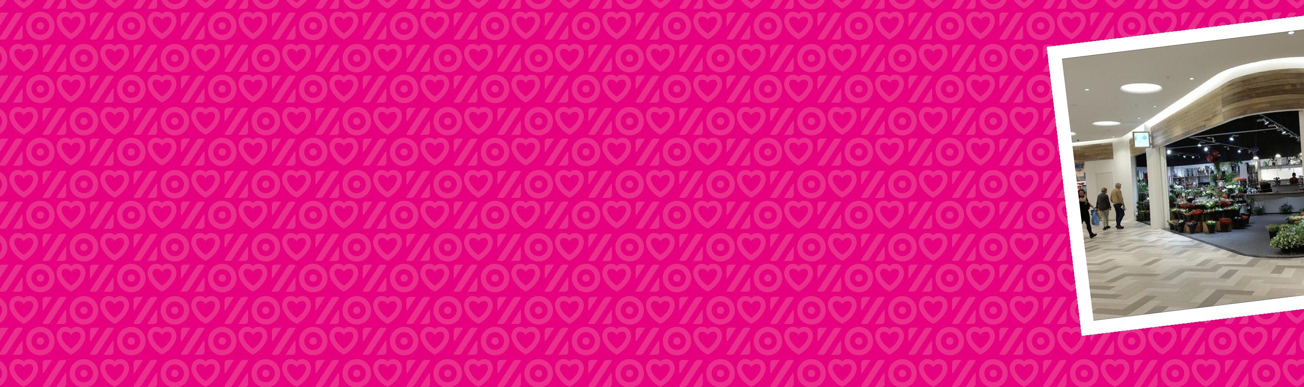 Roze banner met een foto van een lichte overdekte passage met een houten plafond en een bloemenwinkel.